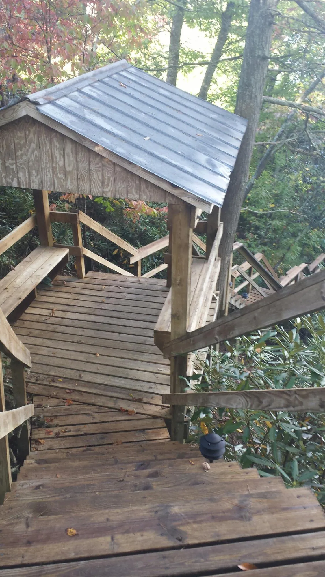 Metal roofed shelter over wooden steps on a wooded walkway — Skylight Repair & Installation work by our crew in Middletown